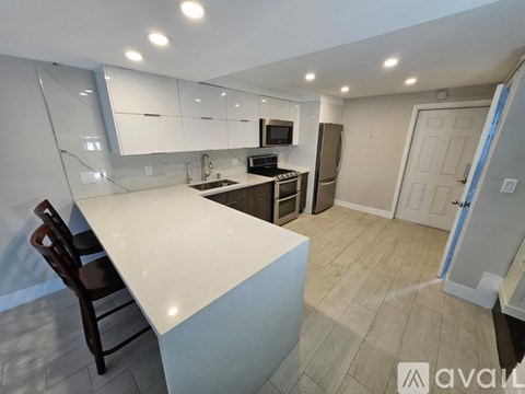 A kitchen with a white countertop and a refrigerator.