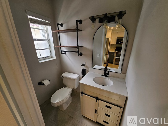 A bathroom with a toilet, sink, and mirror.