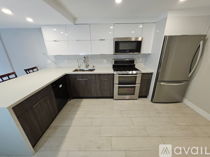 A modern kitchen with a stainless steel refrigerator, oven, and sink.