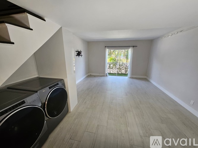 A spacious room with a washer and dryer built into the cabinetry.