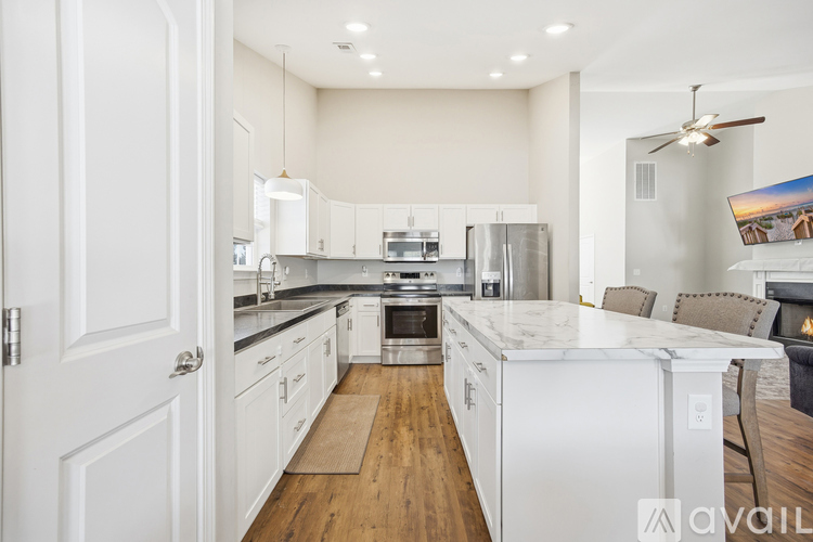 A modern kitchen with white cabinets and stainless steel appliances.