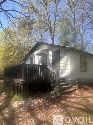 A house with a deck and stairs leading to the front door.