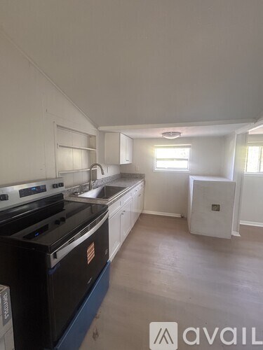 A kitchen with a black stove top oven and white cabinets.
