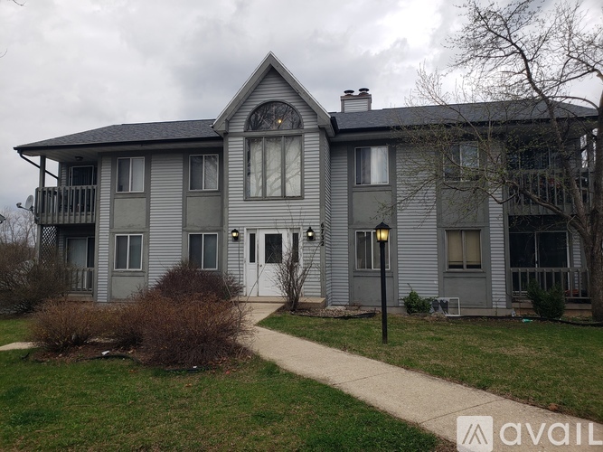 A grey house with a white door and windows.