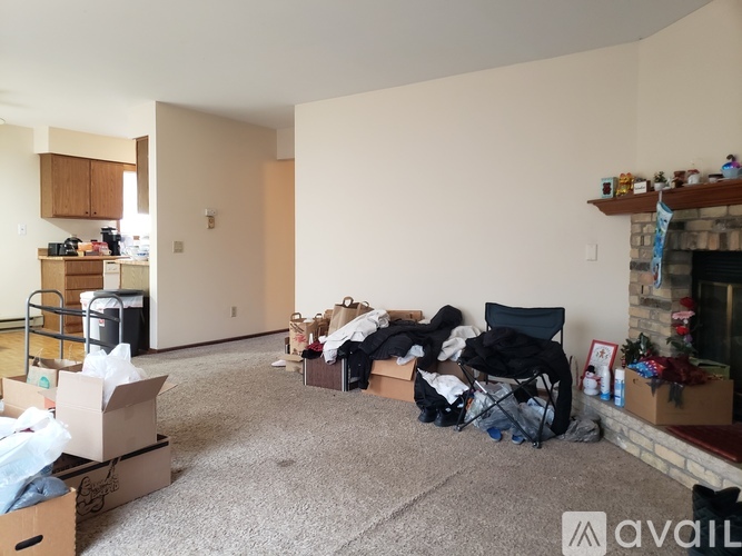 A living room with boxes and items scattered around.
