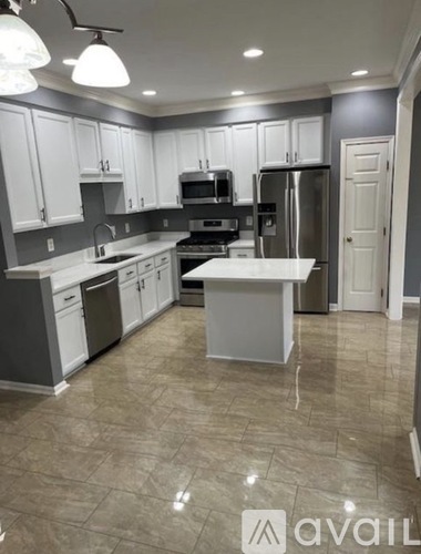 A kitchen with white cabinets and a central island.