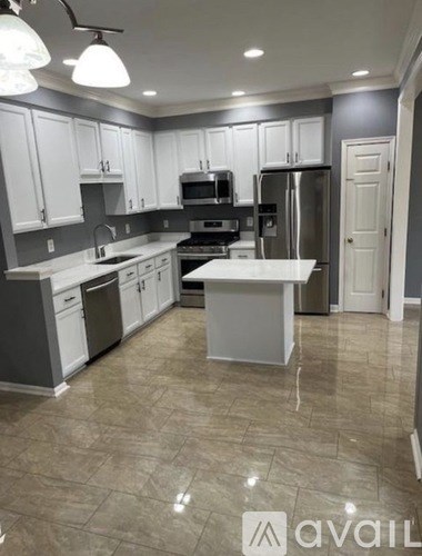 A kitchen with white cabinets and a central island.