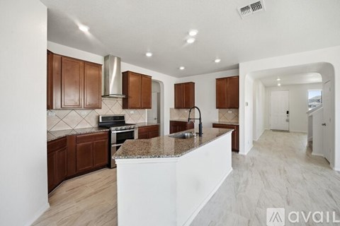 A kitchen with brown cabinets and a granite countertop.