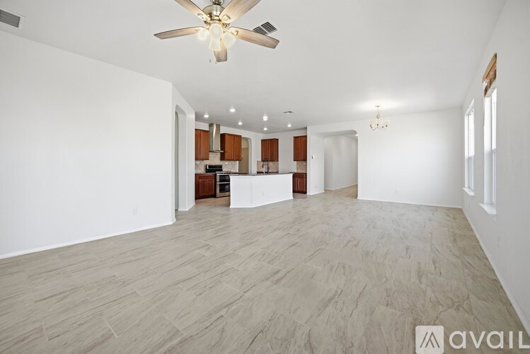 A spacious room with a ceiling fan and lighting fixtures.
