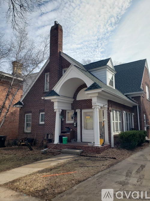 A red brick house with a white door and windows.