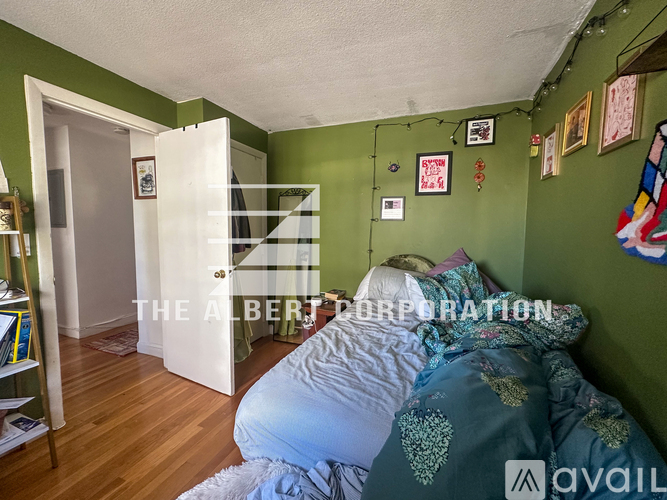 A bedroom with a bed and a green wall.