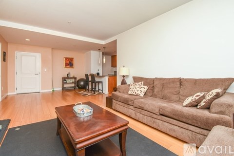 A living room with a brown couch and a wooden coffee table.