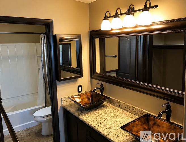 A bathroom with a sink, mirror, and a lit vanity light.