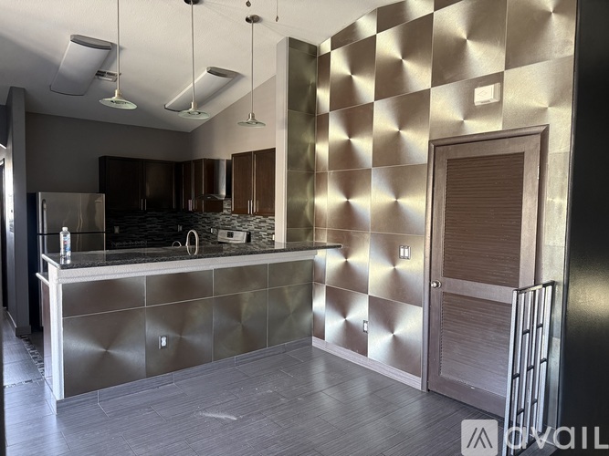 A modern kitchen with a stainless steel backsplash and counters.