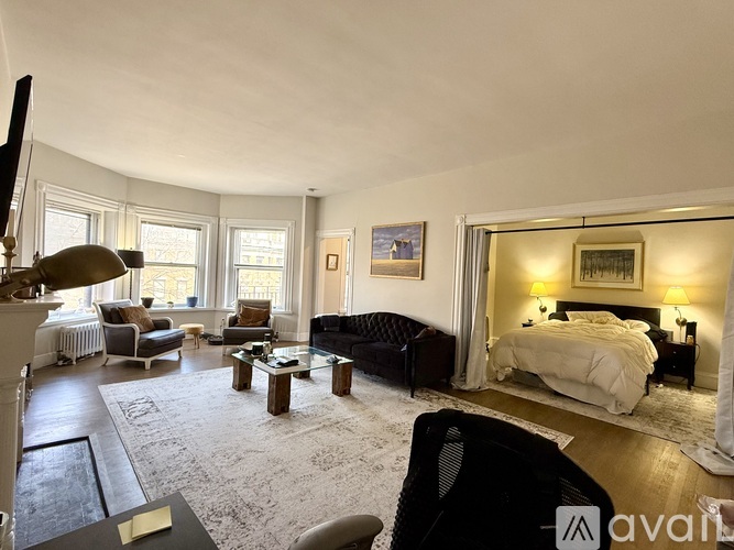 A large, well-lit bedroom with a large bed and a fireplace.