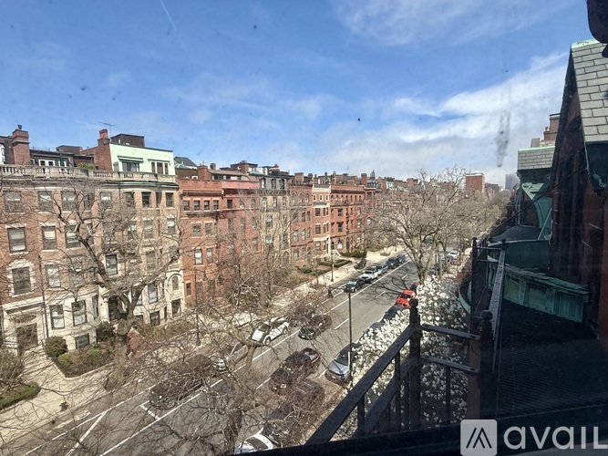 A view of a street from a window with apartment buildings on either side.