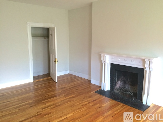 A room with a fireplace and wooden floors.