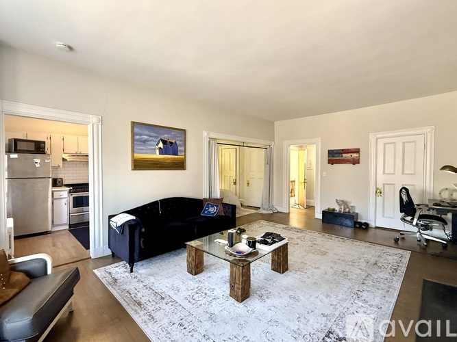 A living room with a black couch and a coffee table.