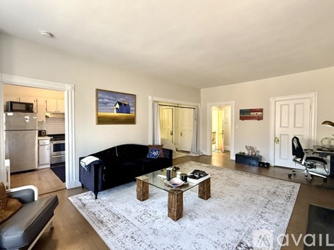 A living room with a black couch and a coffee table.