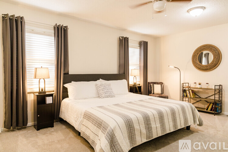 A bedroom with a large bed and a ceiling fan.