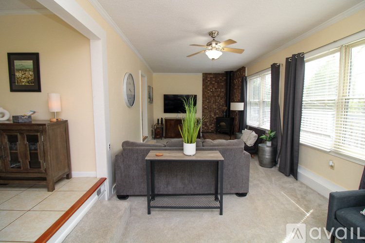 A living room with a grey couch and a ceiling fan.