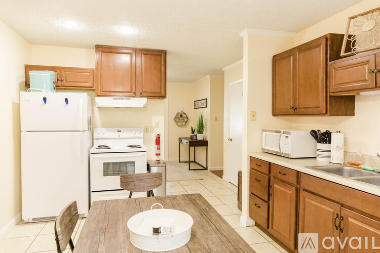 A kitchen with a white refrigerator and wooden cabinets.