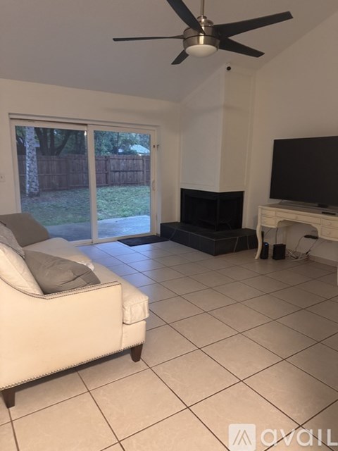 A living room with a white couch and a ceiling fan.