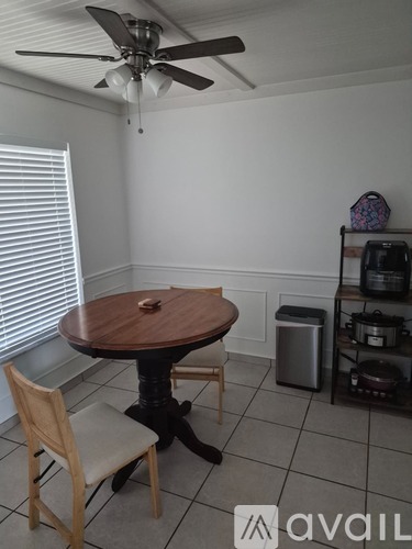 A dining room with a table and chairs.