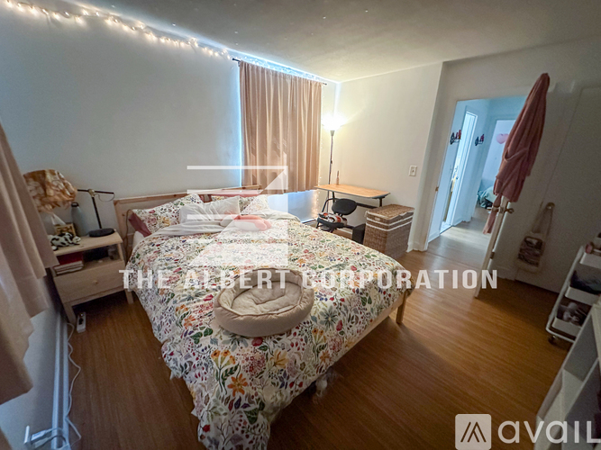 A bedroom with a large bed and a desk with a lamp.