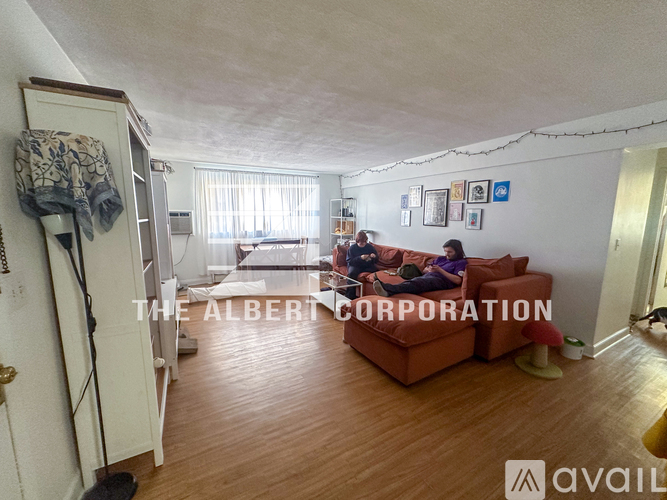 A living room with a couch and a couple sitting on a couch.