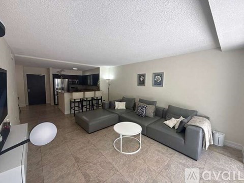 A living room with a grey couch and a white coffee table.