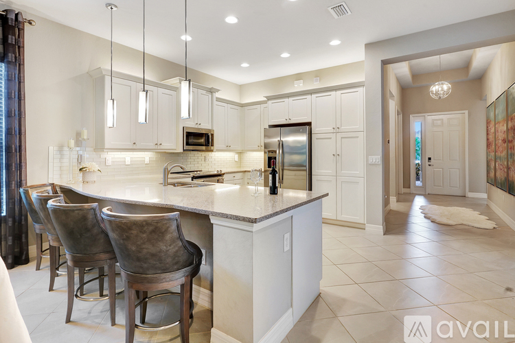 A kitchen with a bar area and chairs.