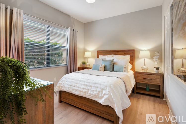A bedroom with a large bed and a potted plant.