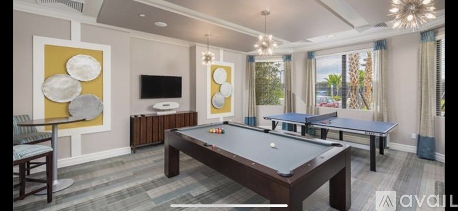 A room with a pool table and a television.