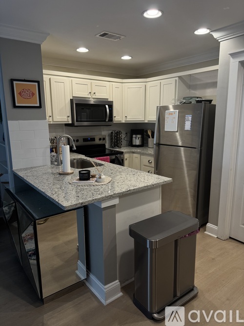 A kitchen with a granite countertop and stainless steel appliances.