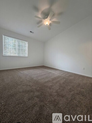 A room with a ceiling fan and a window.
