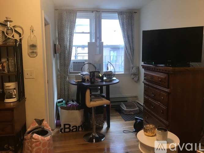 A living room with a TV, a chair, and a table.