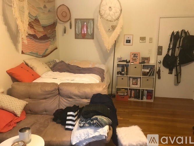 A person is sitting on a couch with a striped shirt and black pants.