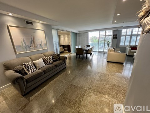A living room with a grey sofa and a painting on the wall.