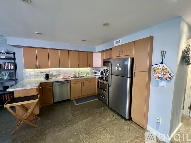A kitchen with a refrigerator, oven, and sink.