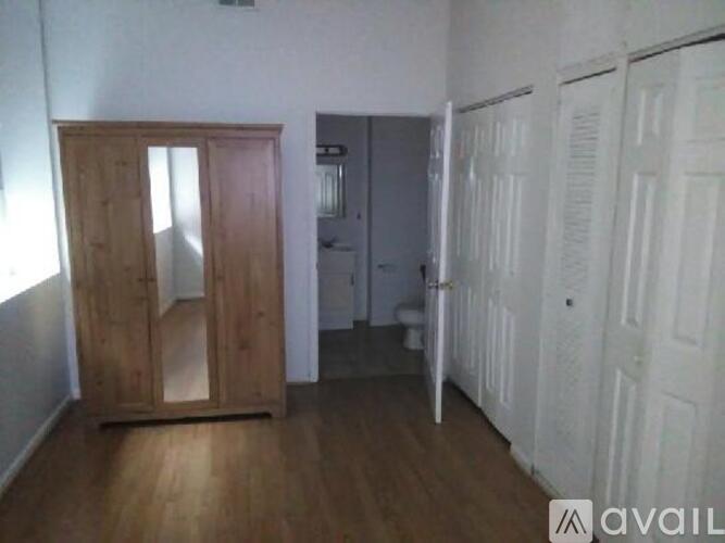A room with a wooden wardrobe and white doors.