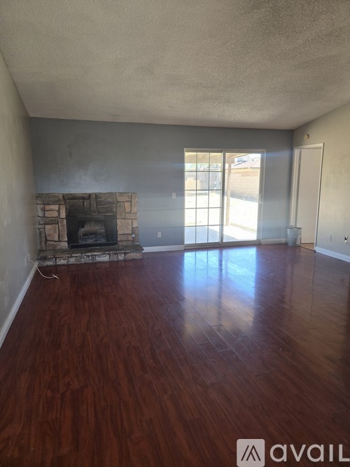 A room with a fireplace and wooden floors.