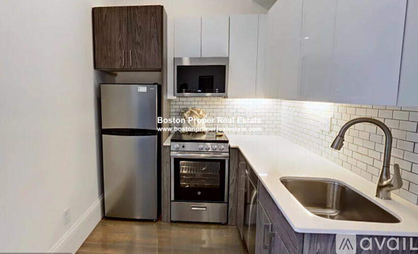 A kitchen with a stainless steel refrigerator, oven, and sink.