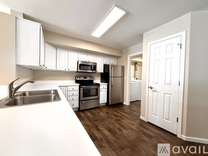 A kitchen with white cabinets and a white counter top.