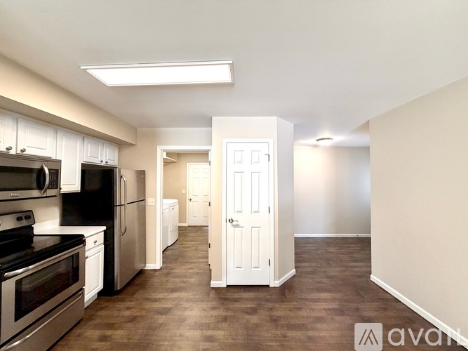 A kitchen with stainless steel appliances and white cabinets.
