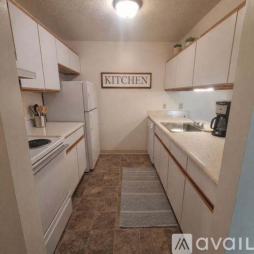 A kitchen with white cabinets and a sign that says "KITCHEN".