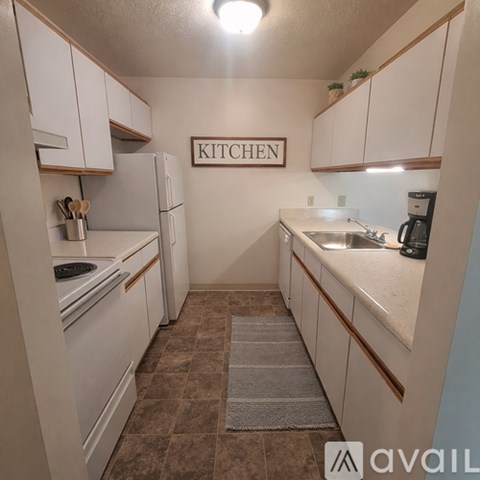 A kitchen with white cabinets and a sign that says "KITCHEN".