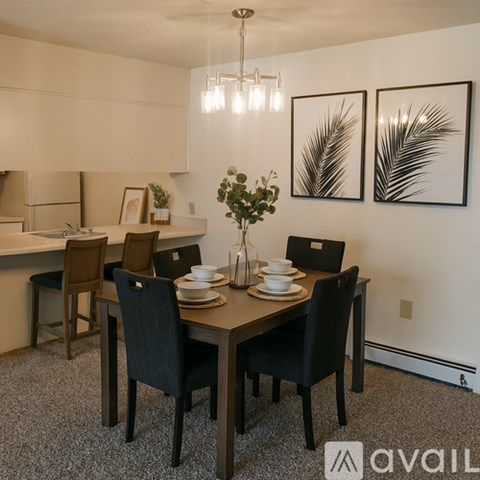 A dining room with a table set for two and two chairs.