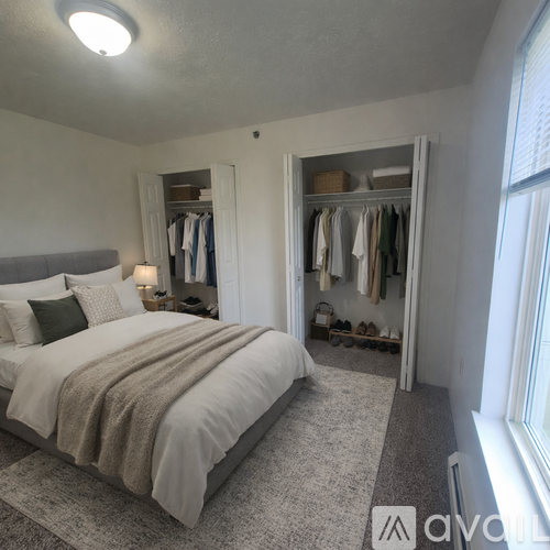 A well-lit bedroom with a large bed and a wardrobe.