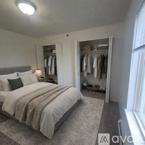 A well-lit bedroom with a large bed and a wardrobe.